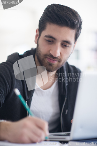 Image of student in school library using laptop for research