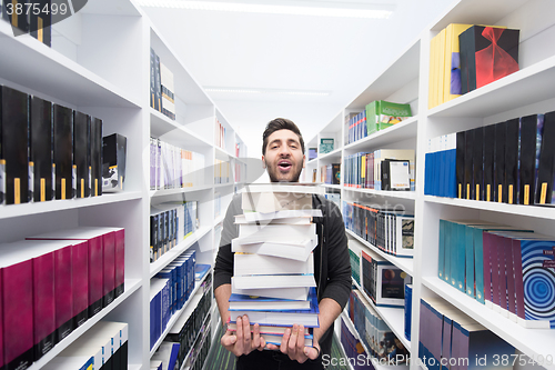 Image of Student holding lot of books in school library