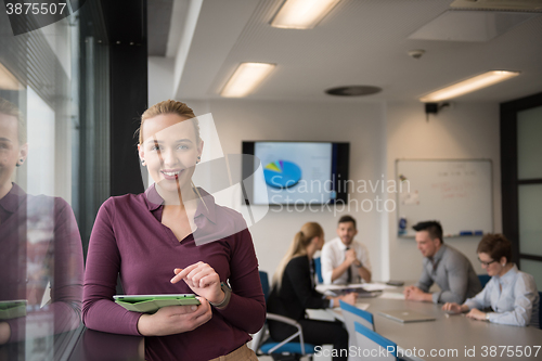 Image of blonde businesswoman working on tablet at office