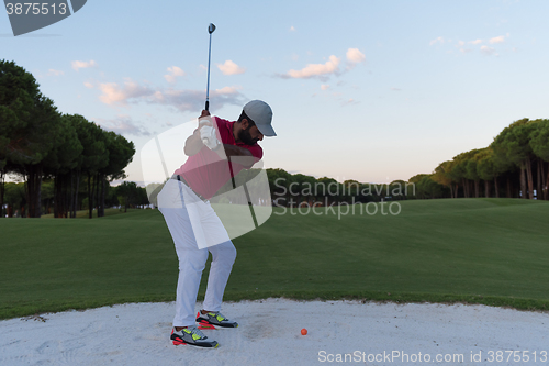 Image of golfer hitting a sand bunker shot on sunset