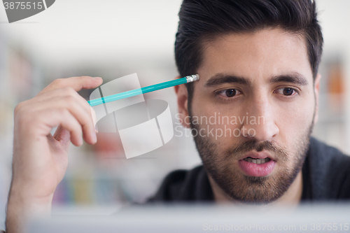 Image of student in school library using laptop for research