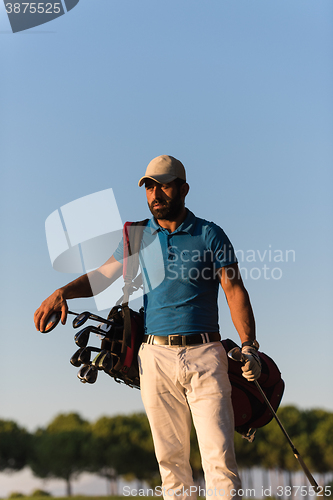 Image of golfer  portrait at golf course on sunset