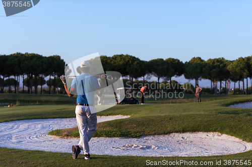 Image of golfer from back at course looking to hole in distance