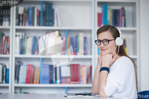 Image of female student study in library, using tablet and searching for 