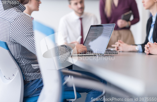 Image of close up of business man hands typing on laptop with team on mee