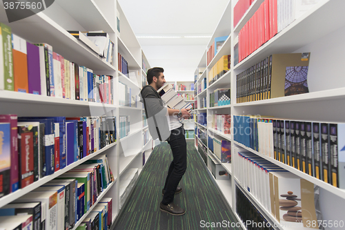 Image of Student holding lot of books in school library