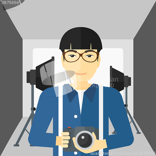 Image of Smiling photographer holding camera.