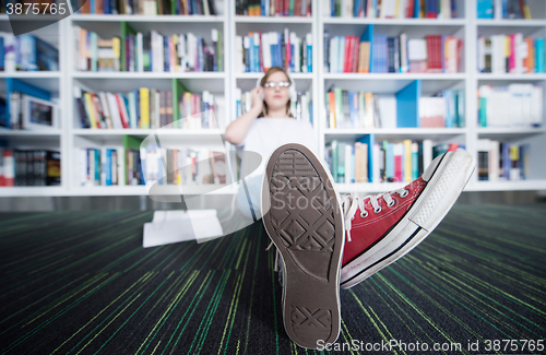 Image of female student study in library, using tablet and searching for 