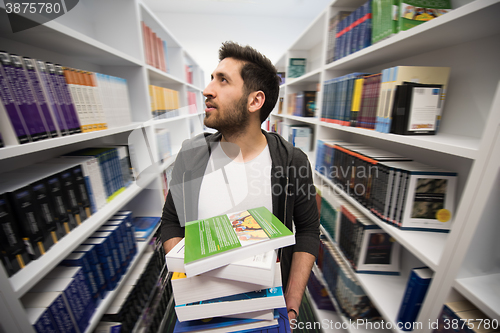 Image of Student holding lot of books in school library