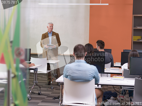 Image of senior teacher and students group in computer lab classroom