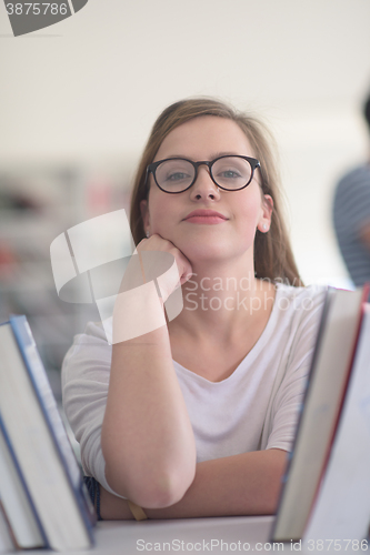 Image of portrait of famale student selecting book to read in library