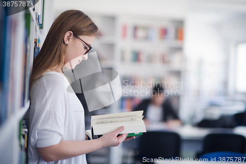 Image of portrait of famale student reading book in library