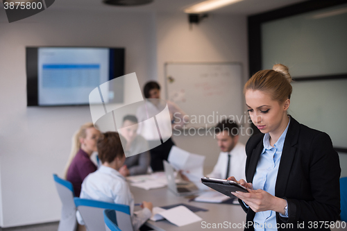 Image of business woman working on tablet at meeting room