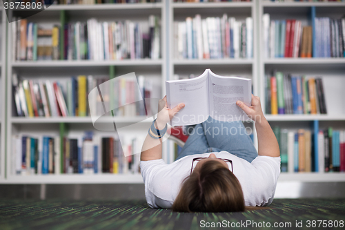 Image of female student study in library, using tablet and searching for 