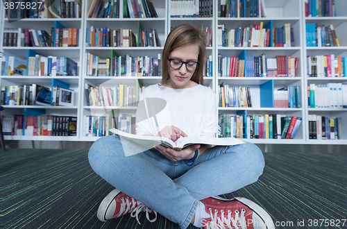 Image of female student study in library, using tablet and searching for 