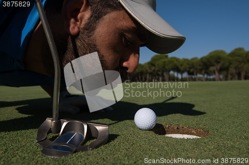 Image of golf player blowing ball in hole
