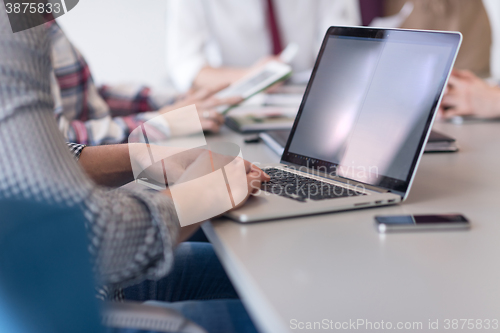 Image of close up of business man hands typing on laptop with team on mee