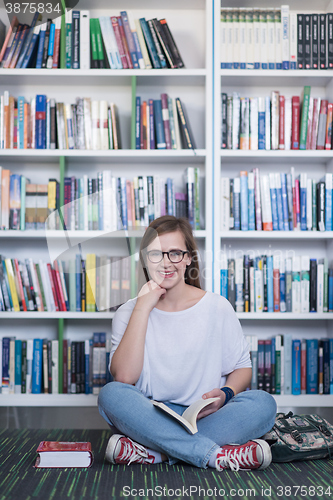 Image of famale student reading book in library