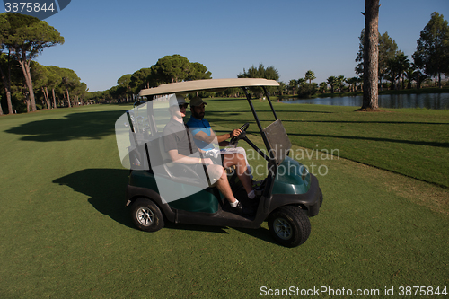 Image of golf players driving cart at course