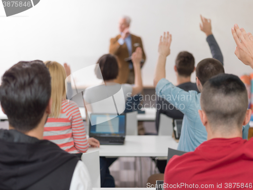 Image of students group raise hands up on class