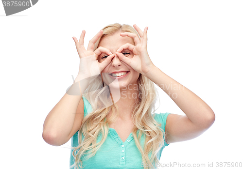 Image of young woman looking through finger glasses