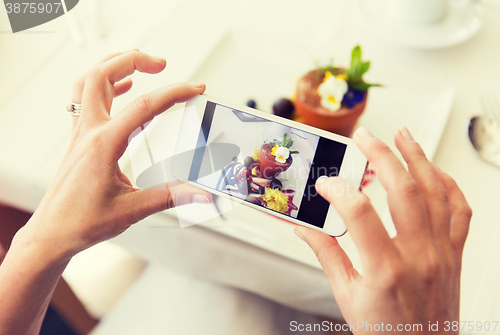 Image of close up of woman picturing food by smartphone