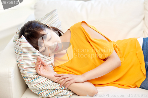 Image of happy asian teenage girl sleeping on sofa at home