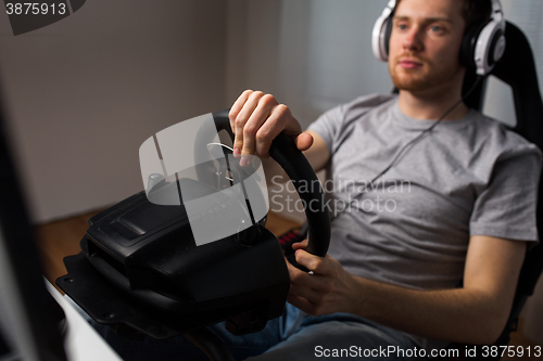 Image of close up of man playing car racing video game