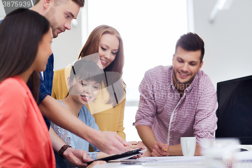 Image of happy creative team with tablet pc at office