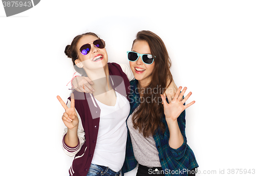 Image of smiling teenage girls in sunglasses showing peace