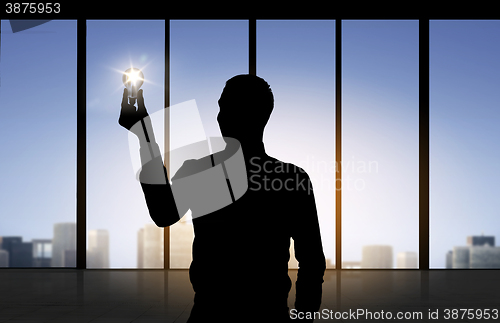 Image of silhouette of businessman holding light bulb