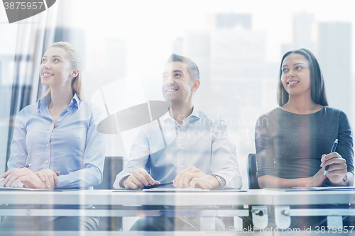 Image of smiling business people meeting in office