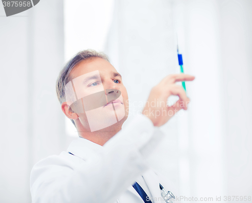 Image of male doctor holding syringe with injection