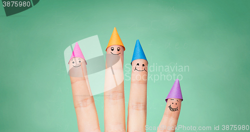 Image of close up of hand with four fingers in party hats