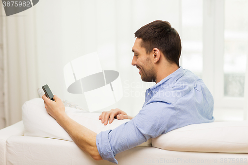 Image of close up of man with smartphone at home