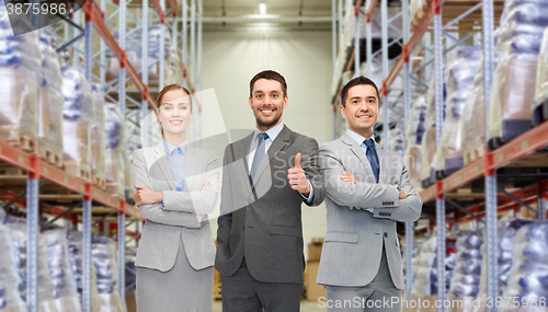 Image of happy business team at warehouse showing thumbs up