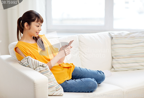 Image of happy asian woman with smartphone at home