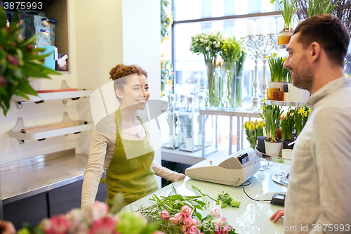 Image of smiling florist woman and man at flower shop