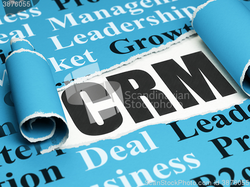 Image of Finance concept: black text CRM under the piece of  torn paper