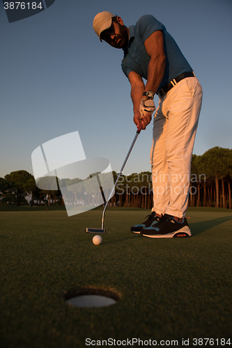 Image of golfer  hitting shot at golf course