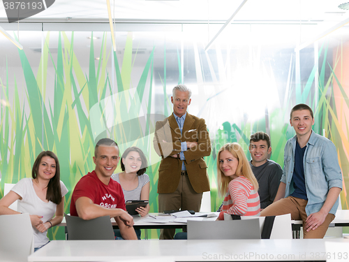 Image of portrait of in teacher in classroom with students group in backg
