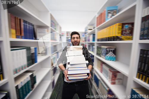 Image of Student holding lot of books in school library