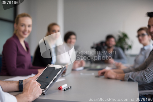 Image of close up of  businessman hands  using tablet on meeting