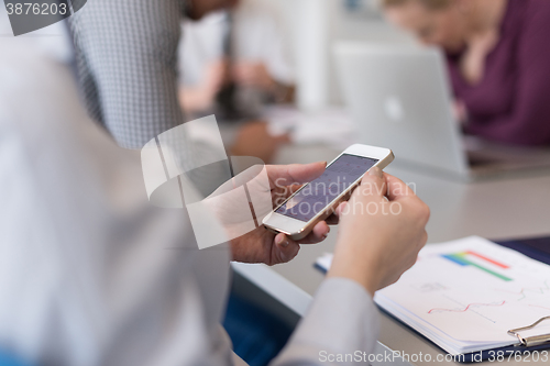 Image of close up of  busineswoman hands  using smart phone on meeting