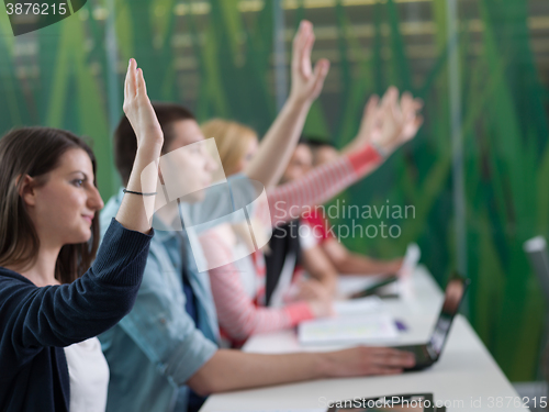 Image of students group raise hands up on class