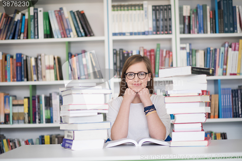 Image of female student study in library, using tablet and searching for 