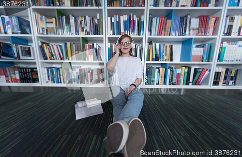 Image of female student study in library, using tablet and searching for 