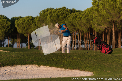 Image of golfer hitting a sand bunker shot on sunset