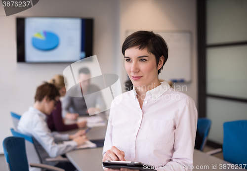 Image of hispanic businesswoman with tablet at meeting room