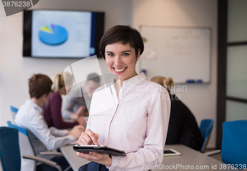 Image of hispanic businesswoman with tablet at meeting room